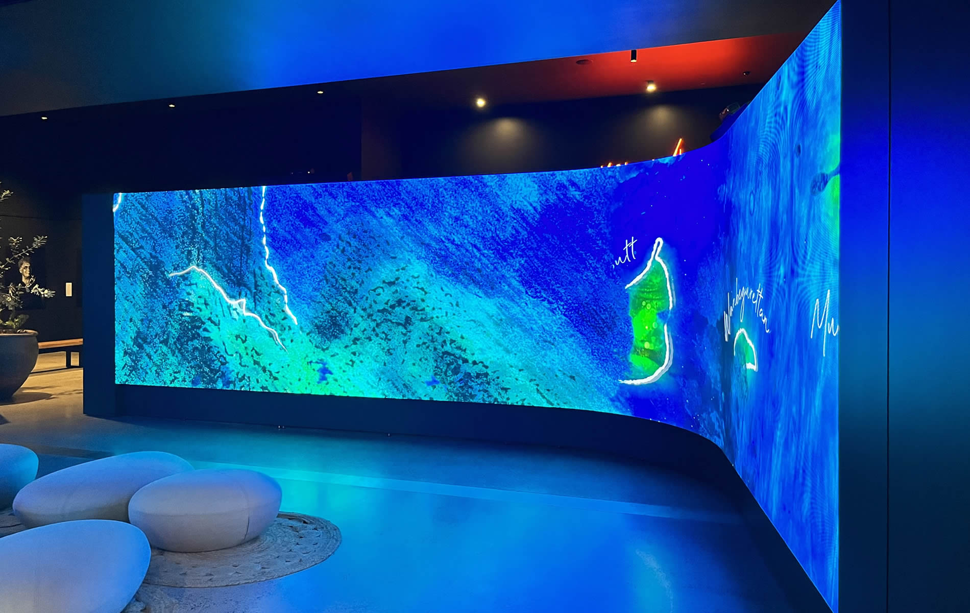 A high-quality curved LED screen with interactive features and directional sound in a museum.